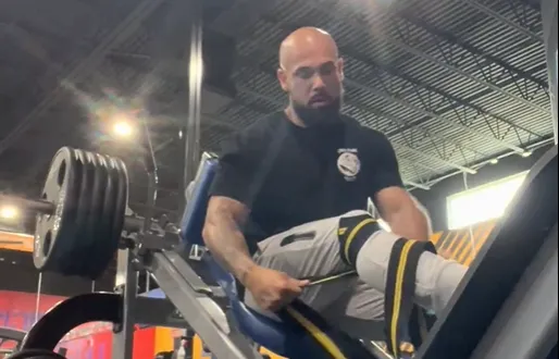Dr. Junior working out on a leg press machine at the gym.