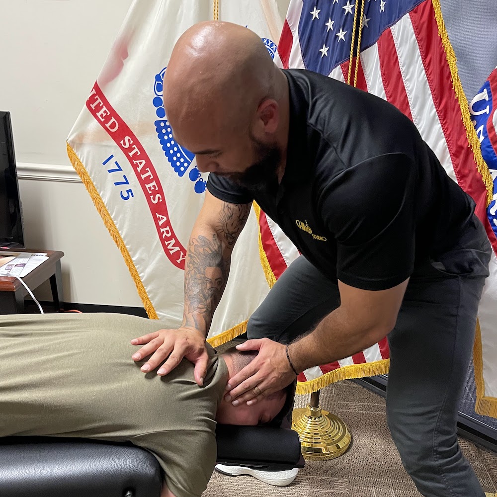 Dr. Isidoro Acevedo Jr giving army patient neck pain treatment