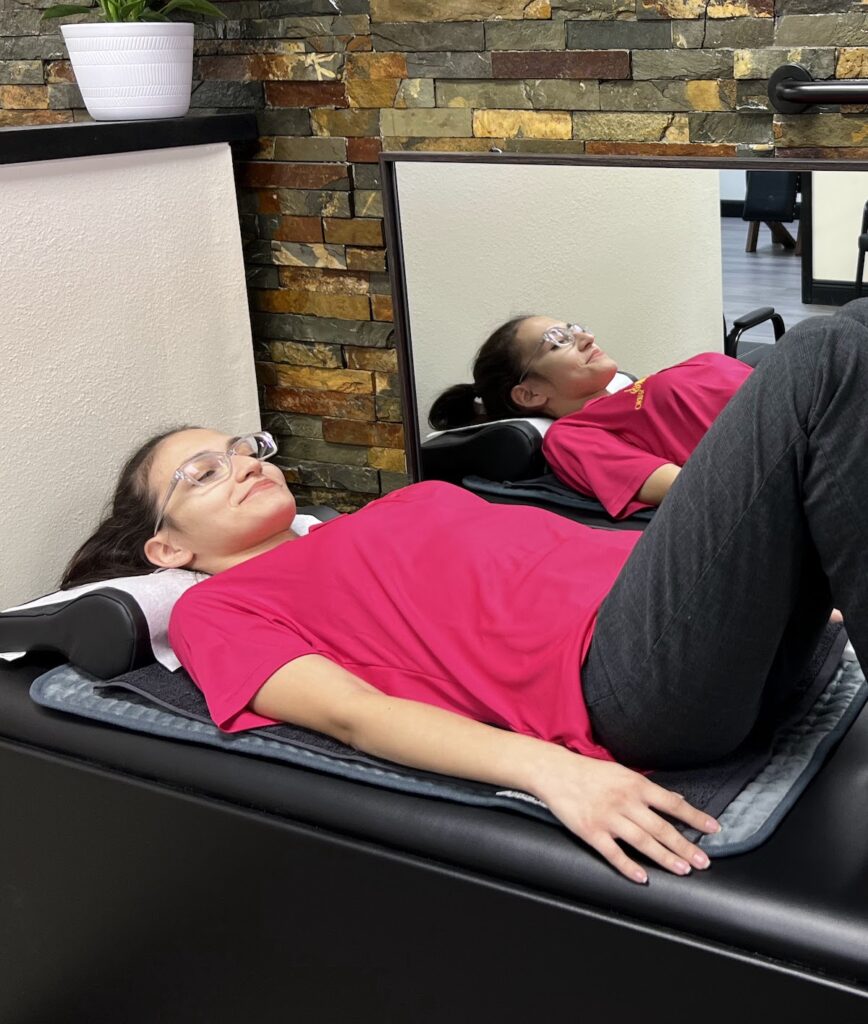 female patient lying in spinal decompression table, chiropractor in cocoa