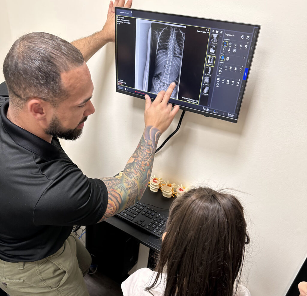 Dr Isidoro Acevedo Jr showing to the girl a spine X-ray result