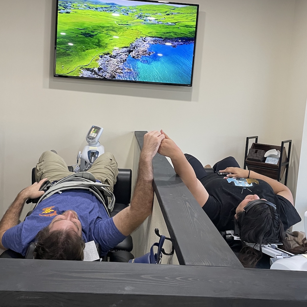 two male patient lying in spinal decompression table waiting for treatment