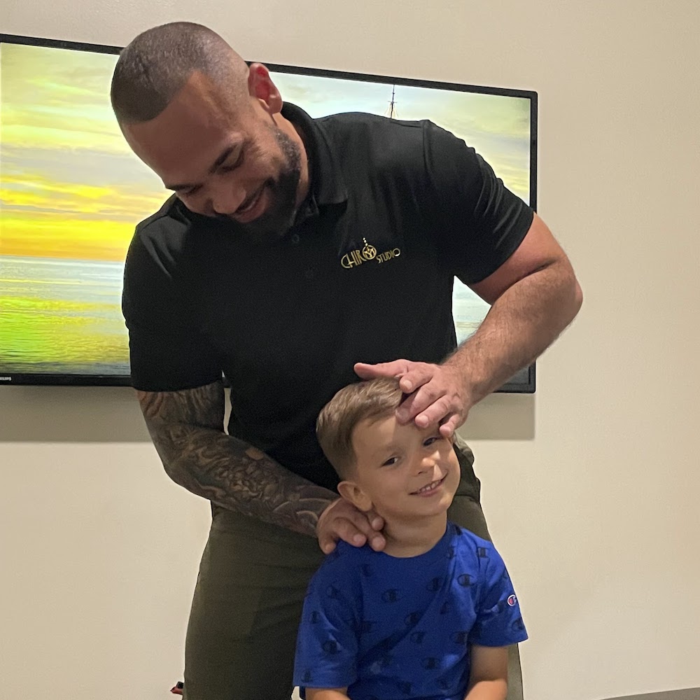 Dr. Isidoro Acevedo Jr giving kid pediatric chiropractic care for neck pain