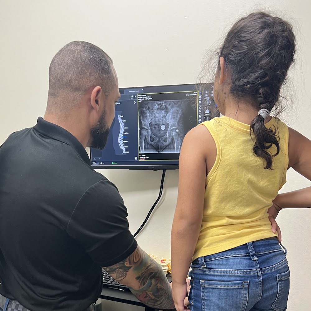 Dr. Isidoro Acevedo Jr showing kid patient her xray reuslt